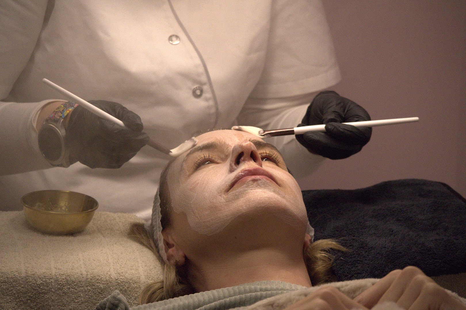 Ilona brengt een verzorgend gezichtsmasker aan bij een klant in de salon